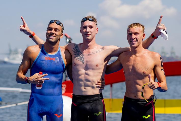 Florian Wellbrock, Gregorio Patrinieri und Marc-Antoine Olivier posen nach dem Freiwasserrennen für das Siegerfoto