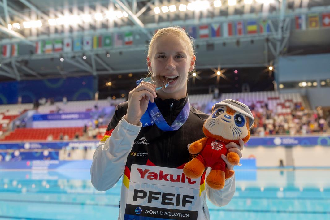 Pauline Pfeif zeigt nach ihrer Siegerehrung ihre WM-Medaille in die Kamera