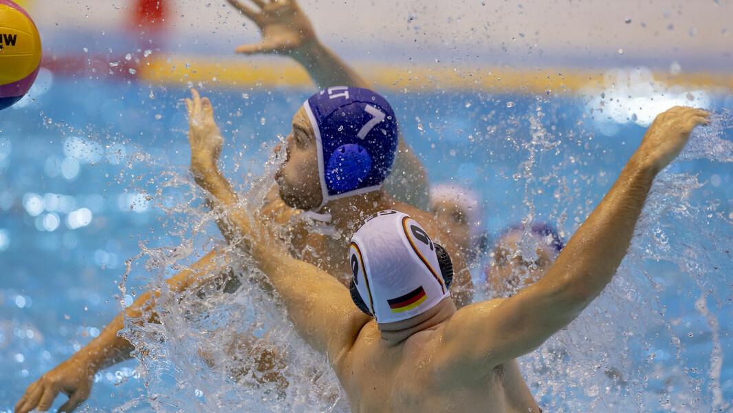 Zwei Wasserballer im Zweikampf um den Ball.