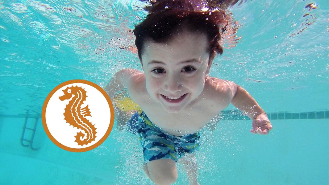 Ein Kind taucht unter Wasser.