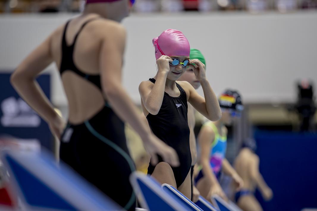 Eine junge Schwimmerin bereitet sich auf ihren Start vor.